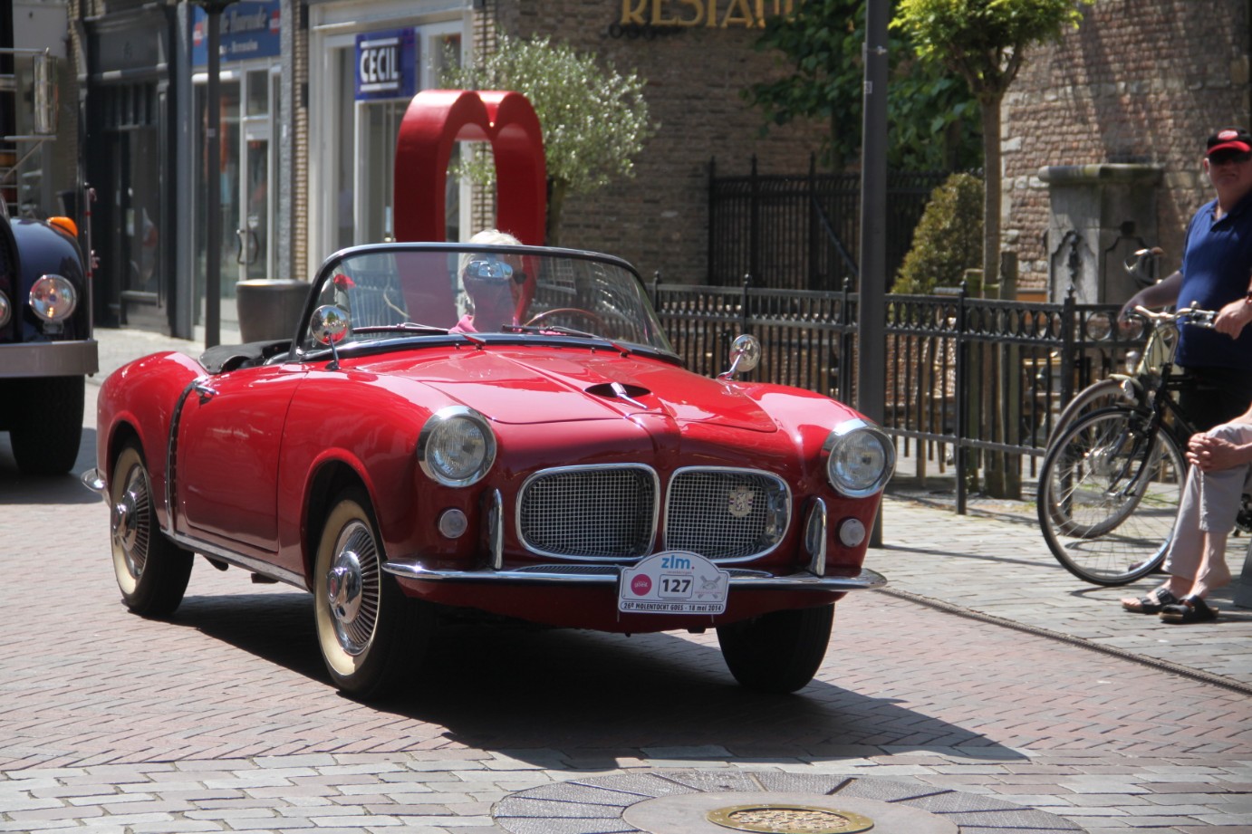 Fiat 1200 cabriolet rouge rue pavée